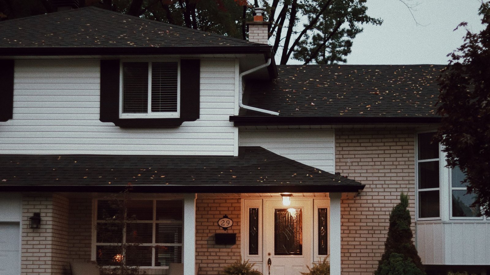 A suburban house with a covered porch and planted beds