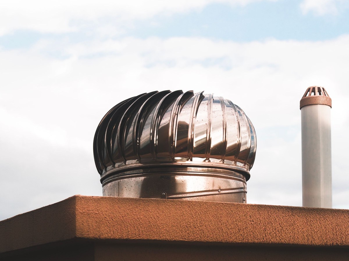 A turbine roof vent turning against a clear sky